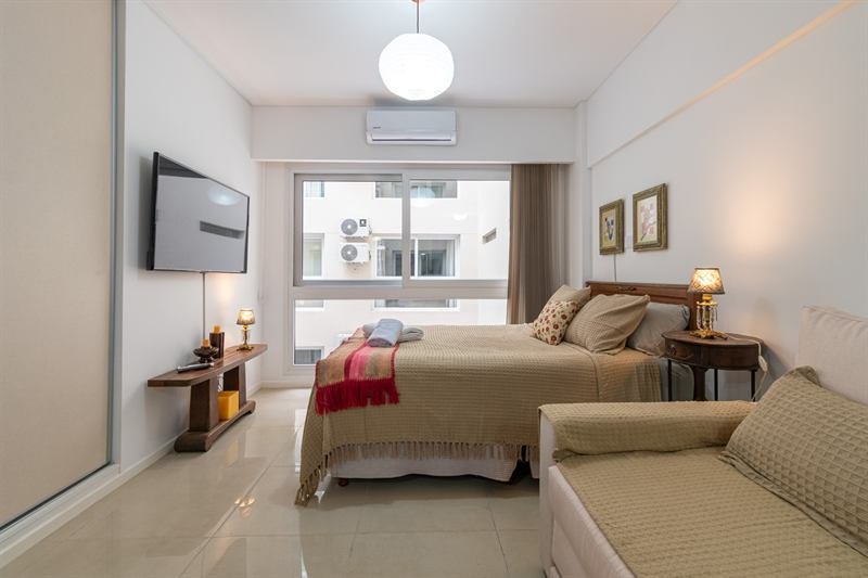 Dormitorio de la propiedad con cama doble, sofá cama y ventanal